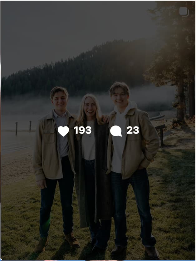 Ben Greenfield's wife standing with their two teenage sons outdoors near a misty lake and forested hillside, all smiling together.